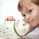 Podle čeho vybrat spoření pro děti? na obrázku dítě a prasátko na spoření
